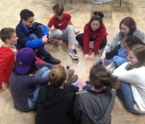 10 youth sitting on the floor in a circle