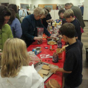 Several church members making peanut butter and jelly sandwiches