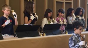 Seven youth performing with handbells