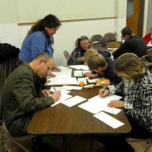 Several church members writing letters at a table