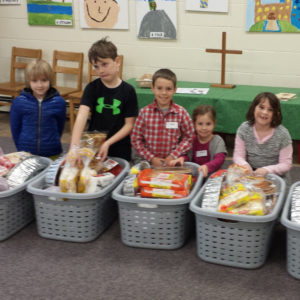 Five youth with laundry baskets filled with food for Thanksgiving