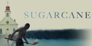 Image of a Native American with a shovel in front of a school